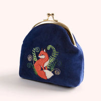 Close-up of blue velvet coin purse with embroidered fox and foliage design