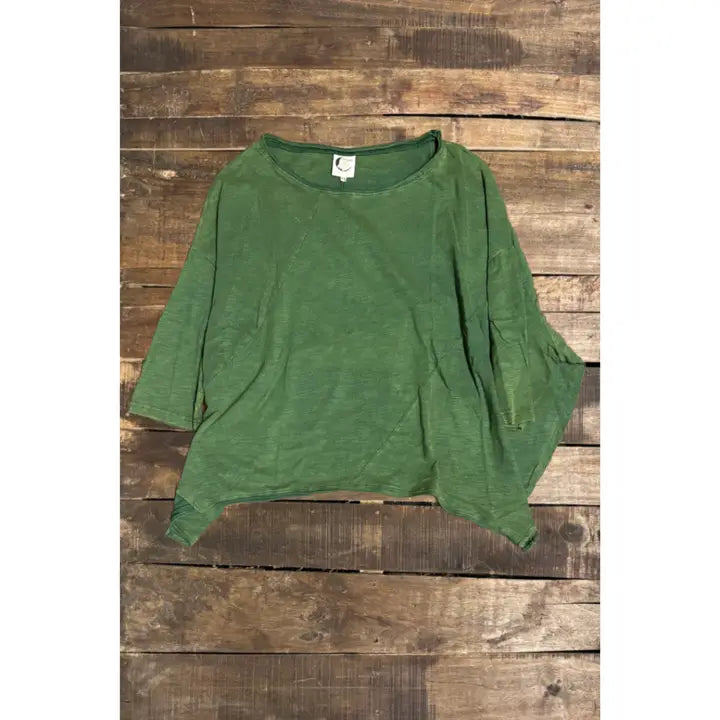 Relaxed fit green women's shirt with three-quarter sleeves displayed on wood background