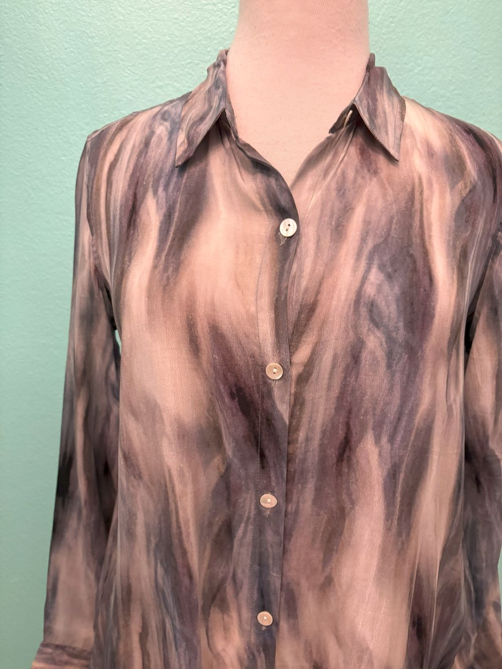 Close-up of smoky marble sheer button-up blouse fabric and buttons
