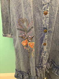 Side floral embroidery and wood button details on a blue ruffle dress