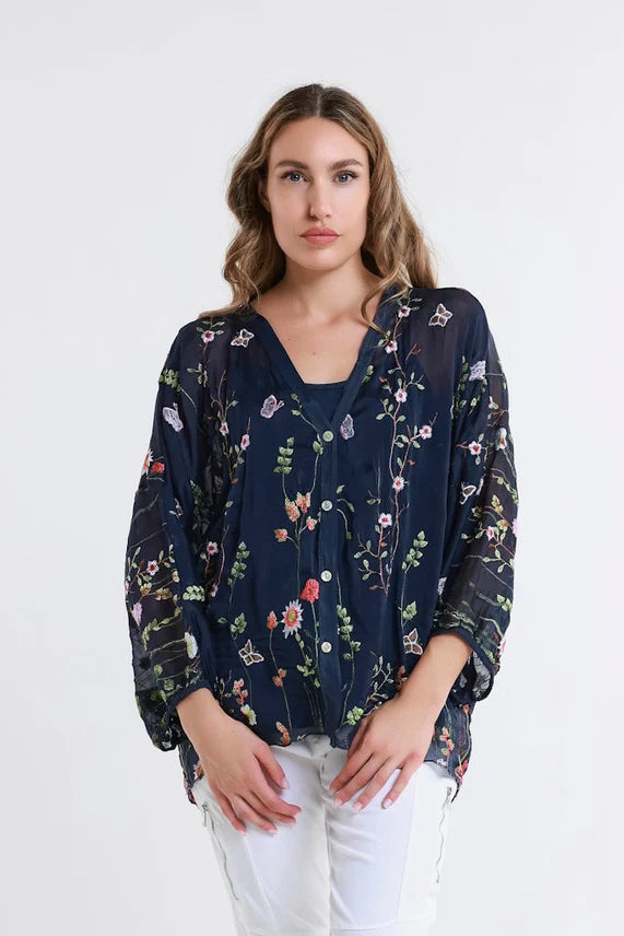 Close-up front shot of a black floral sheer blouse with nature-inspired details