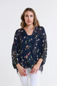 Close-up front shot of a black floral sheer blouse with nature-inspired details