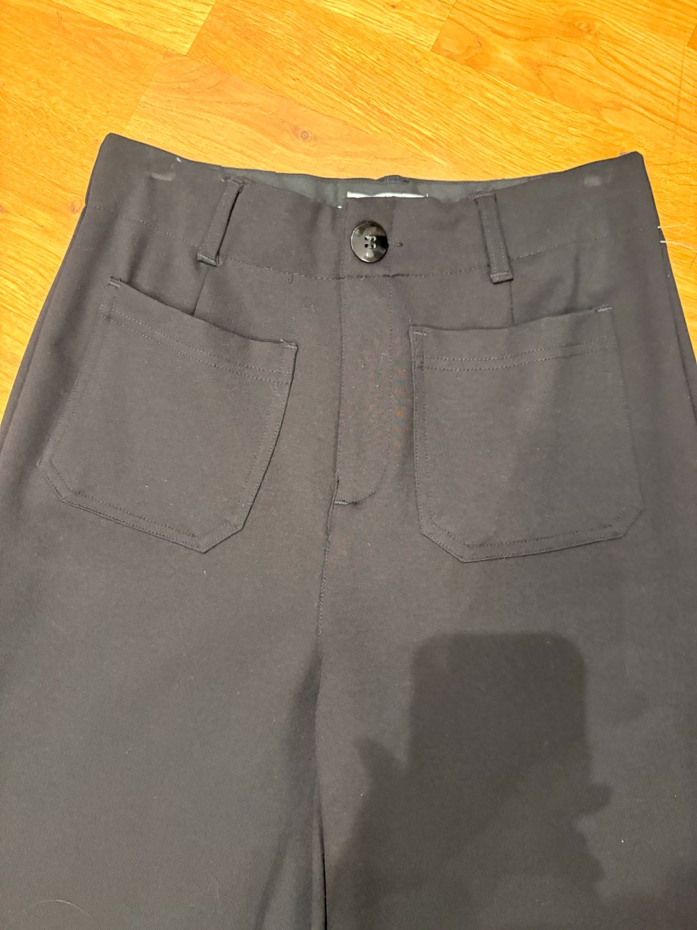 Back view of wide-leg black dress pants on model