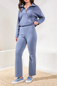 Front view of a woman modeling a lavender lounge set featuring a half-zip sweatshirt and flared pants