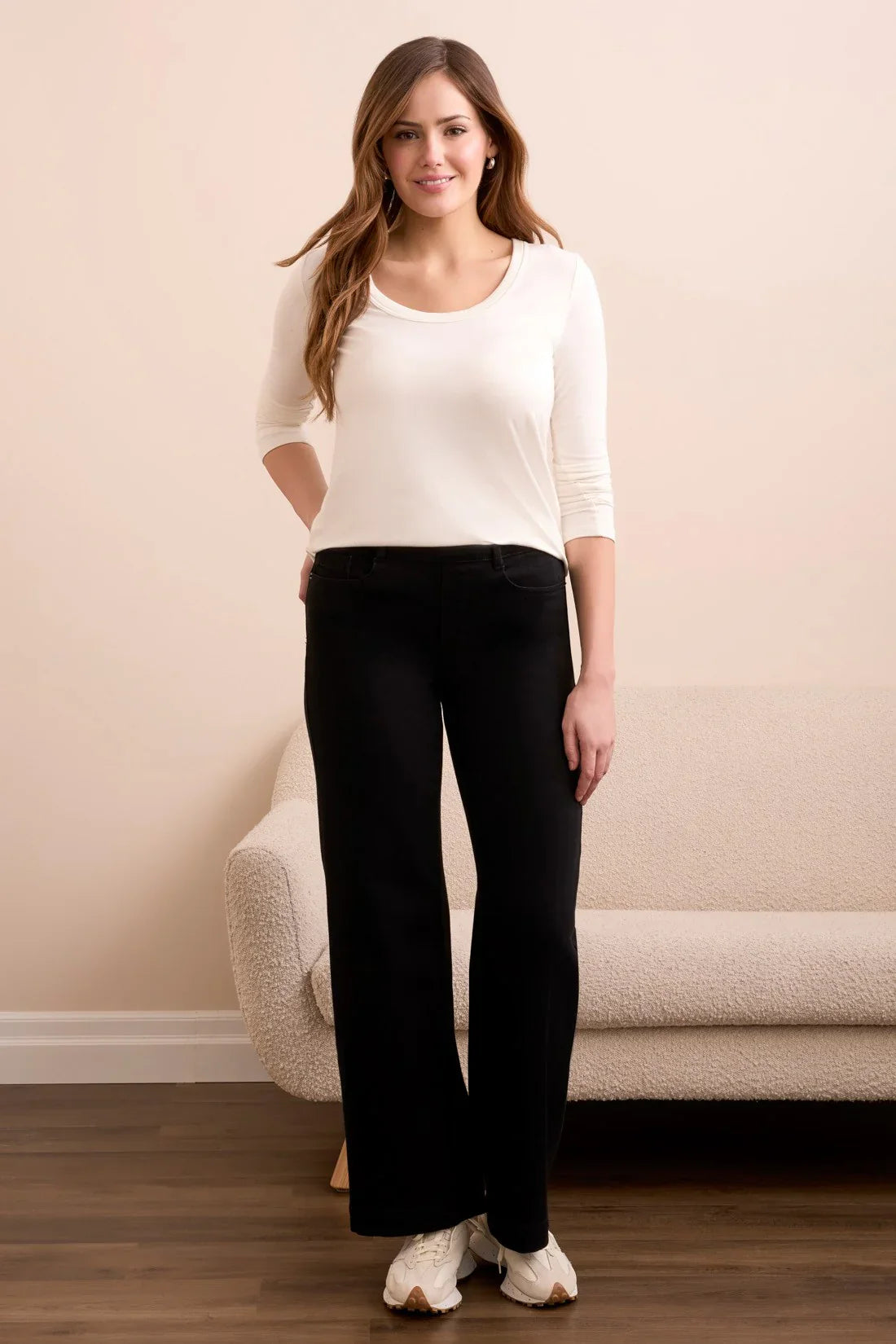 Front view of a woman modeling black wide-leg pants and a white long-sleeve top