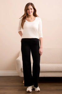 Front view of a woman modeling black wide-leg pants and a white long-sleeve top