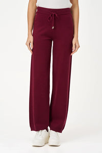 Front view of woman wearing burgundy relaxed-fit knit jogger pants with drawstring