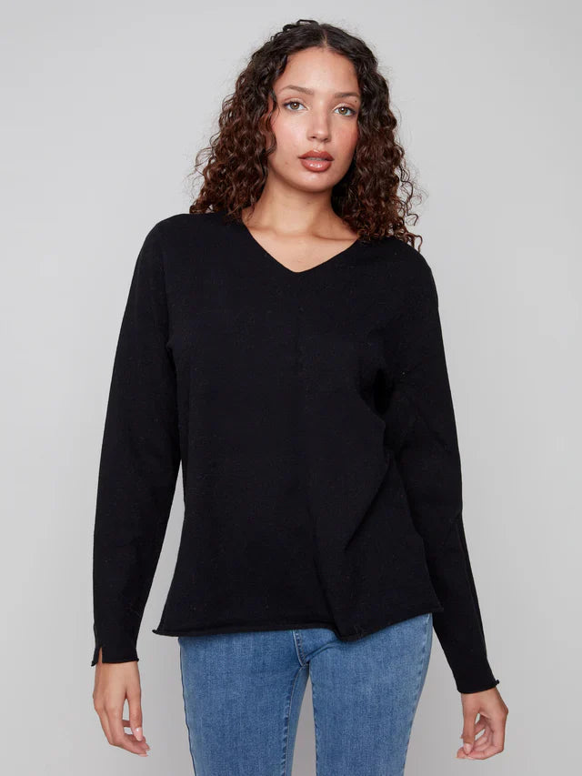 Front view of a woman wearing a black V-neck sweater and jeans