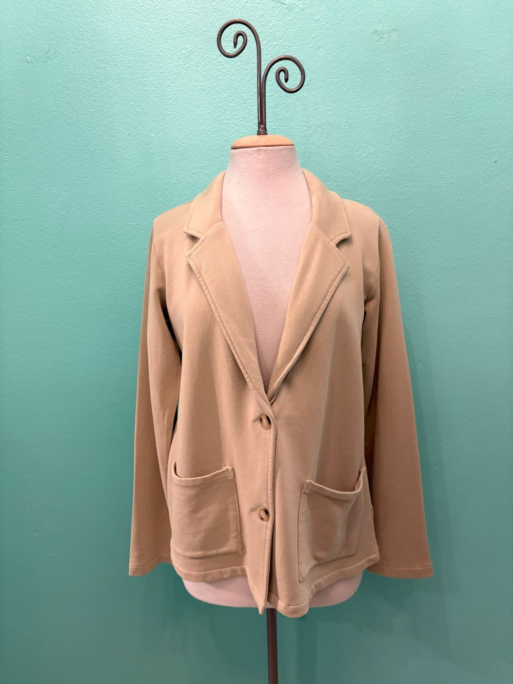 Front view of beige knit blazer with patch pockets and button closure on mannequin