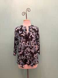 Front view of a black blouse with blue butterfly design on mannequin