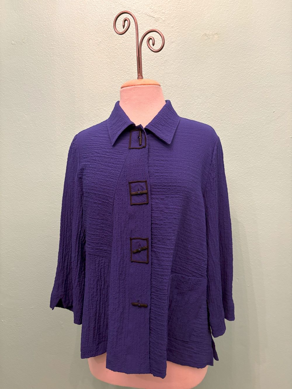 Front view of indigo textured jacket with unique square button closure