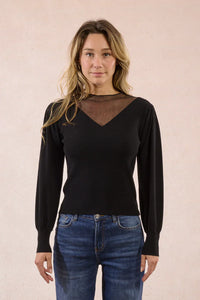 Front view of woman modeling black knit sweater with mesh panel at neckline