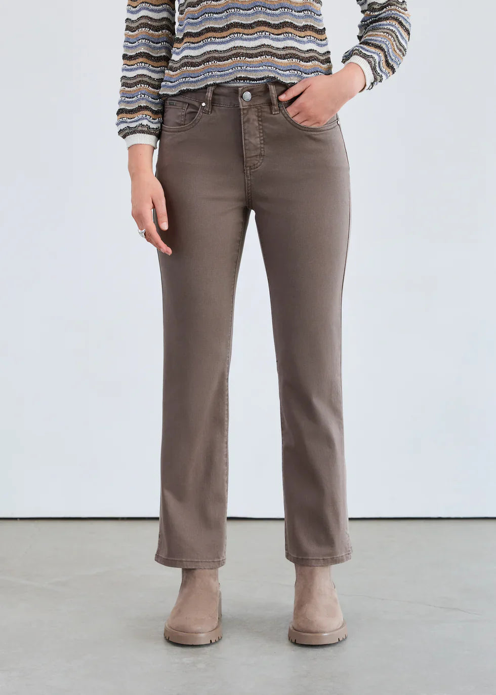 Front view of taupe straight-leg mid-rise jeans styled with ankle boots