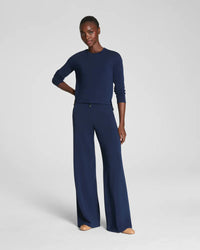 Full body shot of a woman in a relaxed-fit navy loungewear set with wide-leg pants