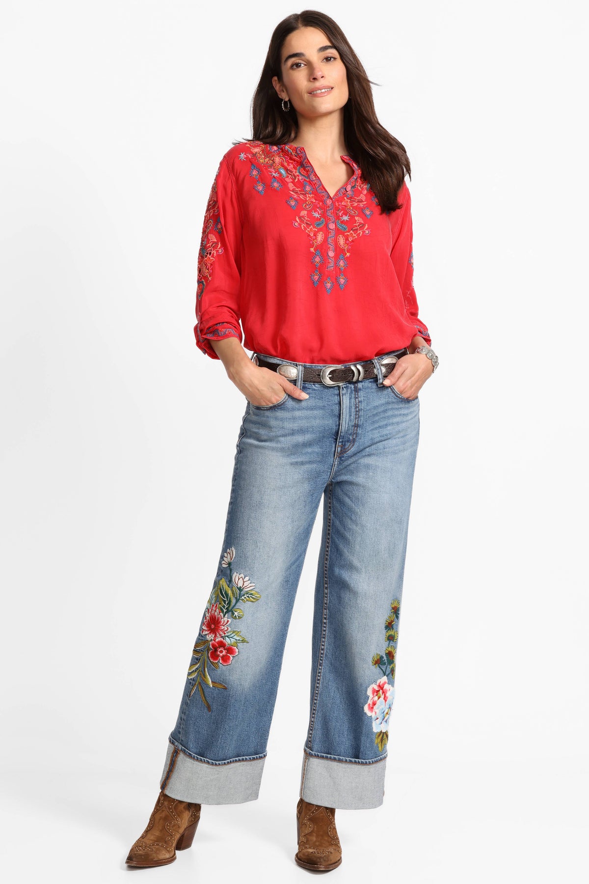 Front view of wide-leg jeans with bold floral embroidery, styled with a red embroidered blouse and boots