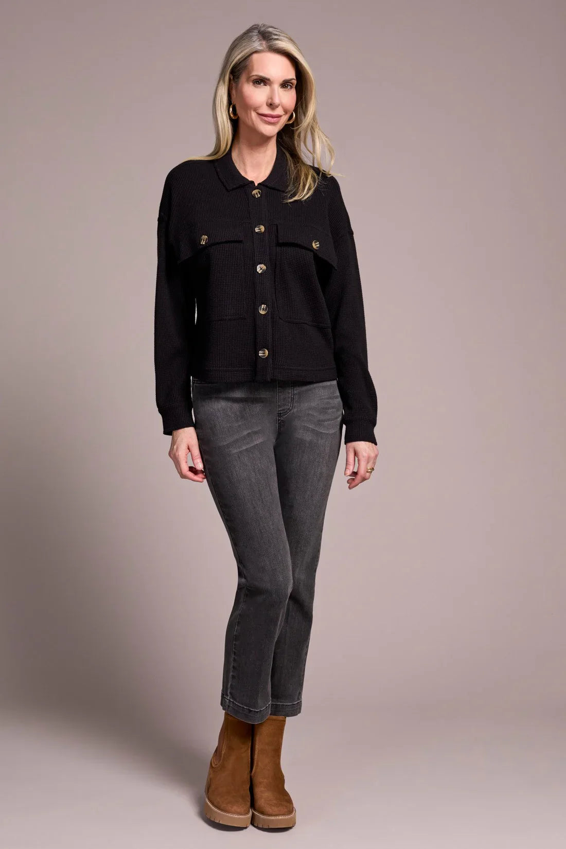 Woman standing in charcoal high-rise straight jeans paired with a black jacket and brown boots