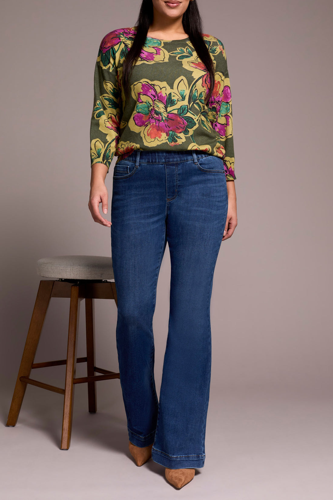 Full body front view of woman modeling classic flare stretch blue jeans