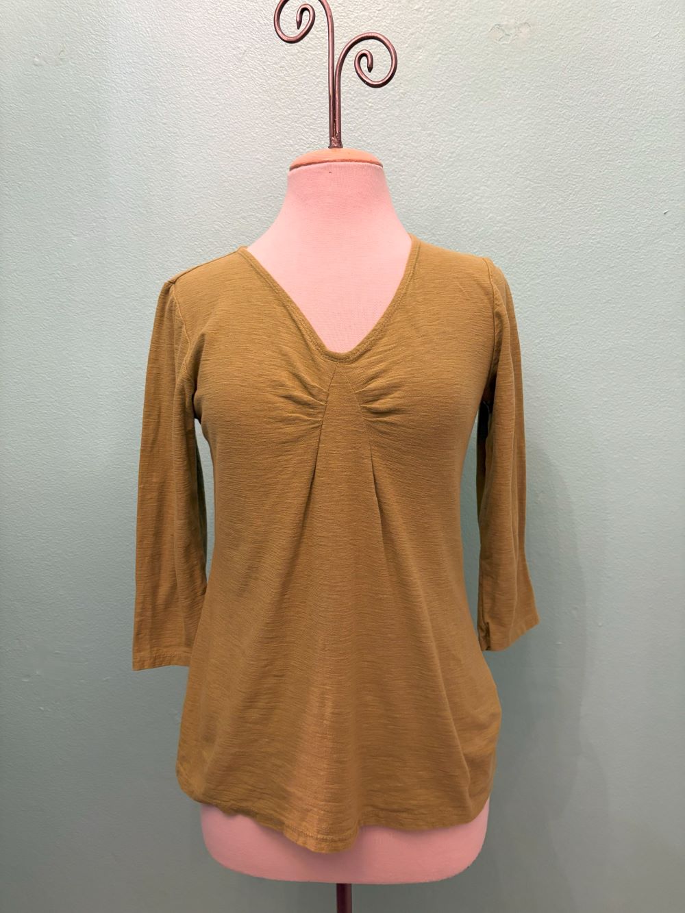 Front view of golden mustard 3/4 sleeve V-neck top with ruched detail