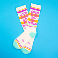 Two cream socks with 'Good Moms Say Bad Words' text on a vibrant blue surface