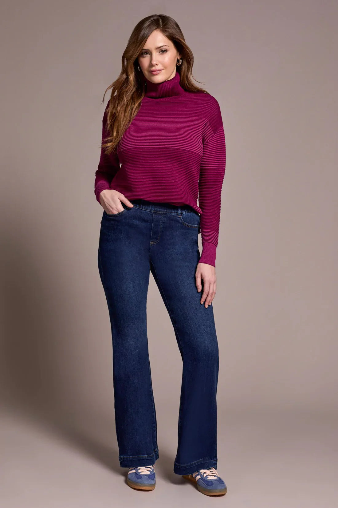 Woman modeling flattering high-rise bootcut jeans with magenta turtleneck