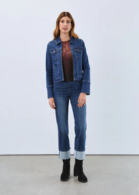 Woman wearing high-waisted straight leg jeans with large cuffed hems and denim jacket