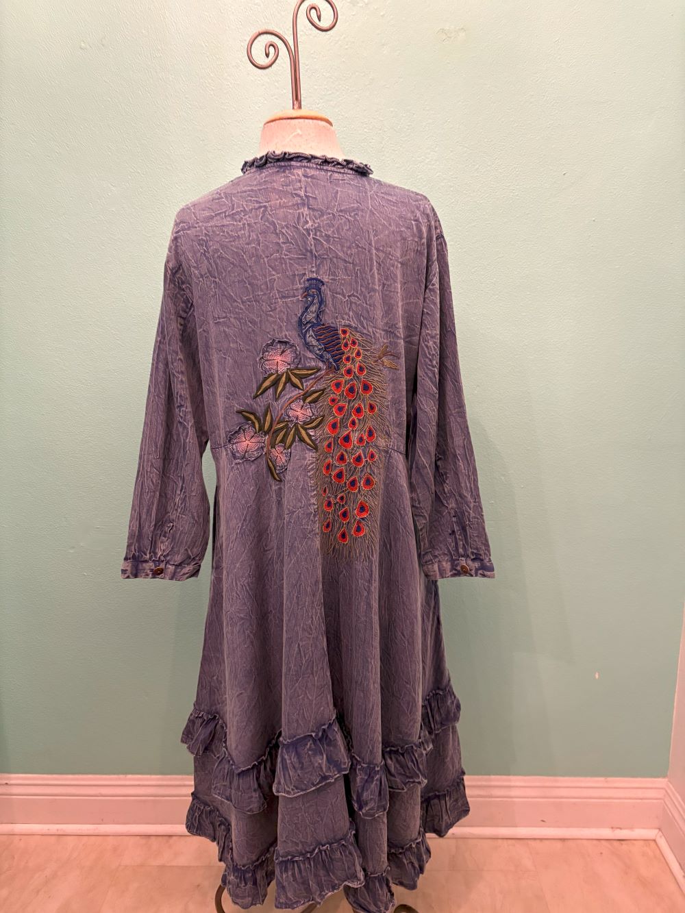 Full back view of indigo ruffle dress with colorful peacock embroidery