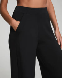 Close-up of jet black wide-leg lounge pants showing pockets and waistband detail