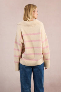 Back view of a model in a cream and pink striped knit sweater with wide collar