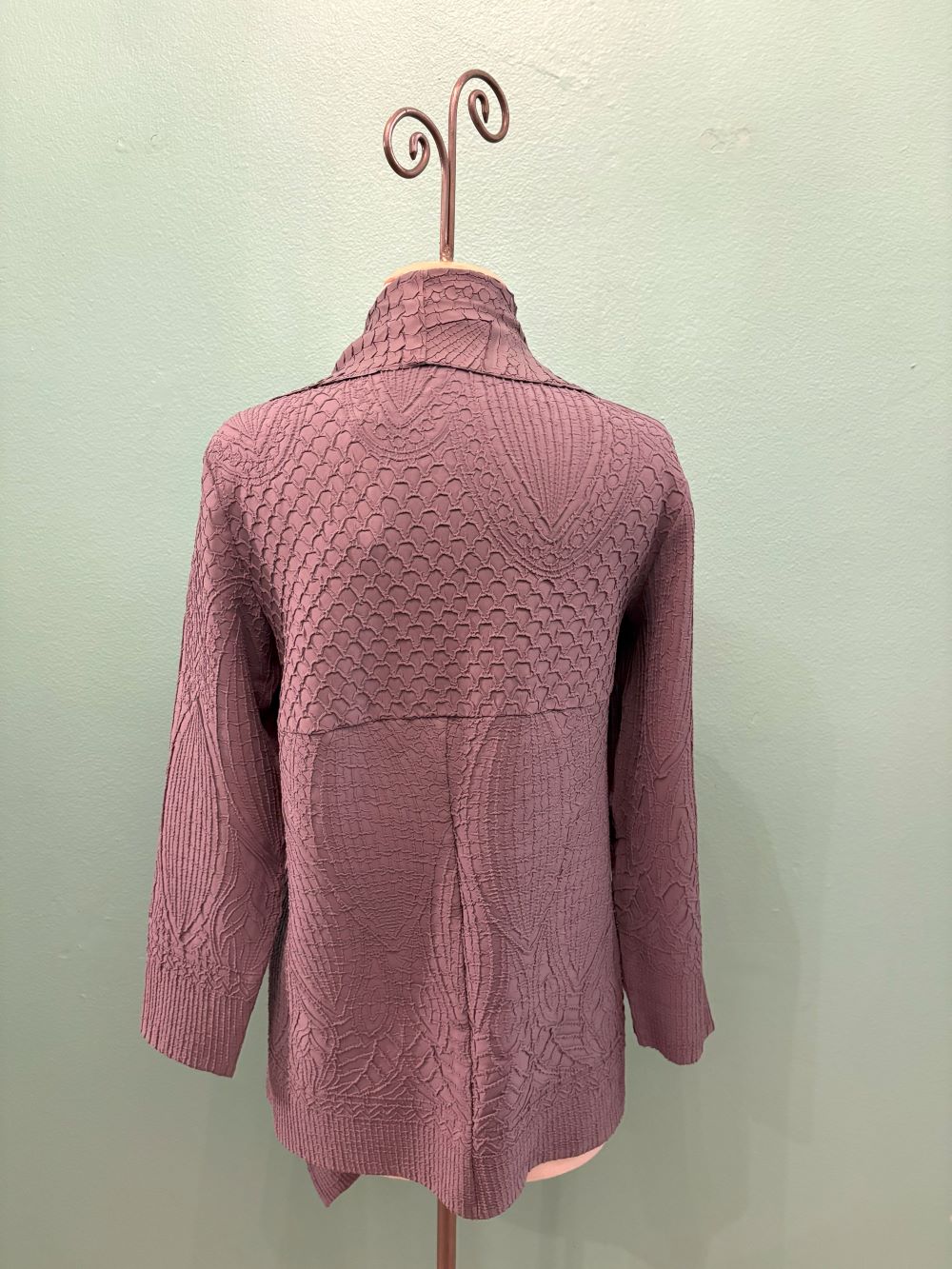 Back view of mauve textured knit cardigan with intricate patterns