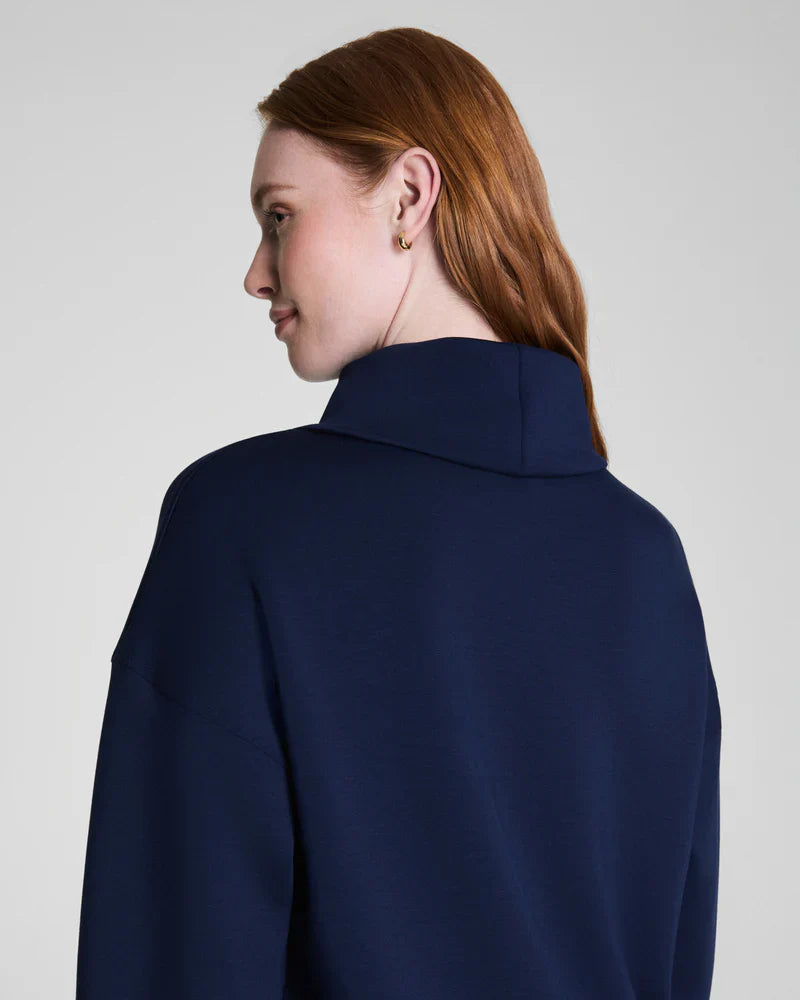 Back view showing mock neck collar and relaxed fit of navy sweatshirt