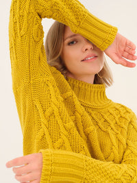 Woman wearing a yellow cable knit turtleneck sweater, closeup showing texture and style