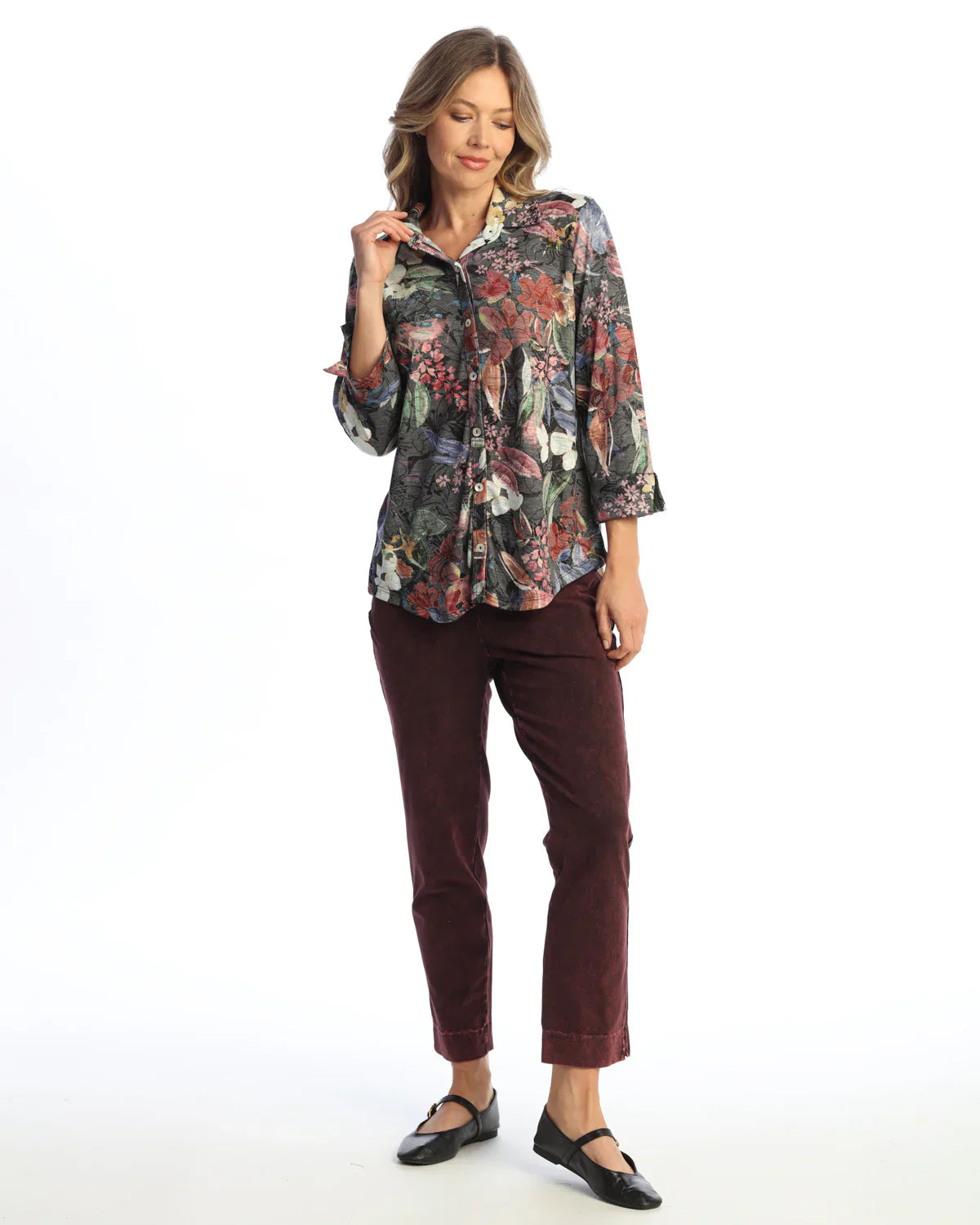 Woman wearing a 3/4 sleeve floral button-up blouse with burgundy pants and black flats