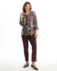 Woman wearing a 3/4 sleeve floral button-up blouse with burgundy pants and black flats