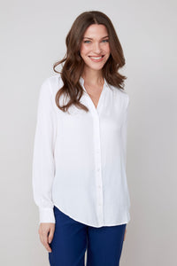 Smiling woman in classic white button-up blouse, front view