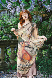 Woman in forest wearing illustrated woodland animals scarf around shoulders