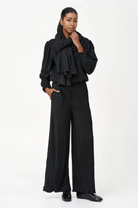 Woman modeling black wave-texture wide-leg pants with matching scarf and blouse