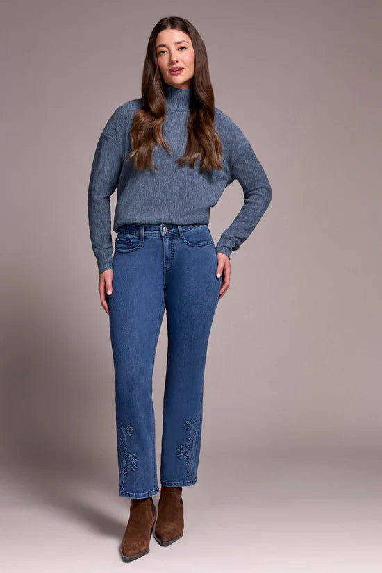 Woman in straight-leg floral embroidered denim jeans and brown boots