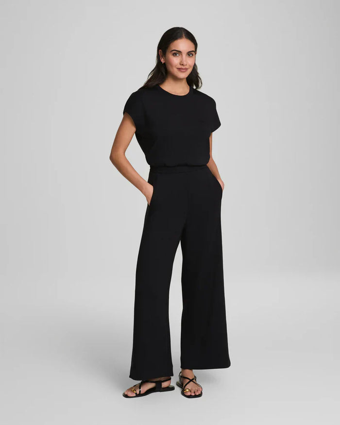 Full outfit front view of black wide-leg jumpsuit with pockets