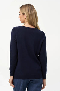 Back view of a woman wearing a navy blue V-neck sweater