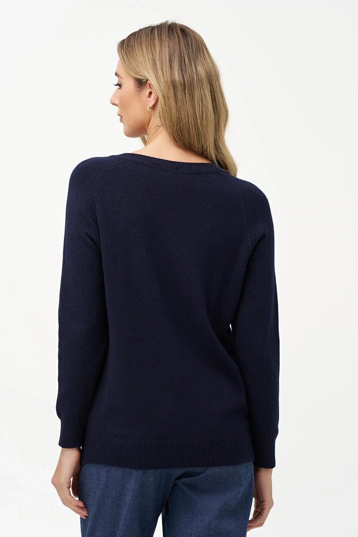 Back view of a woman wearing a navy blue V-neck sweater