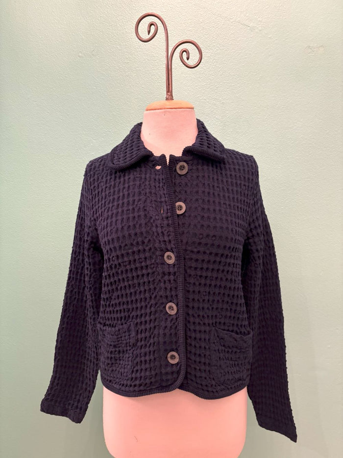 Front view of navy waffle knit button-up cardigan displayed on a mannequin