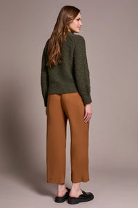 Back view of a woman wearing a cozy olive green textured sweater
