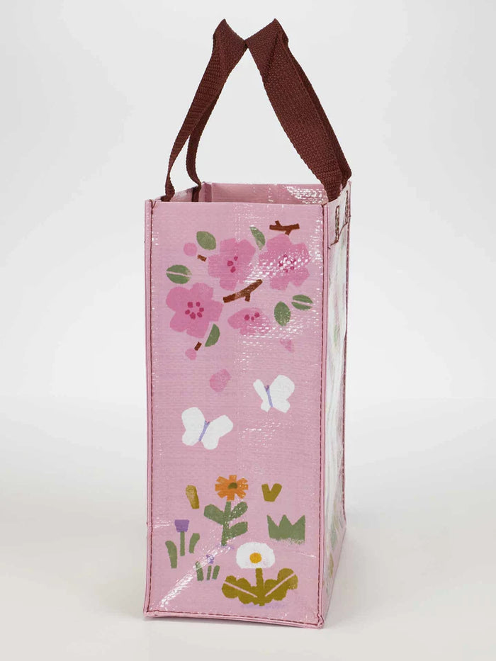 Side view of pink reusable bag decorated with flowers, butterflies, and green leaves