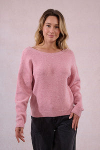 Model smiling in a pink sequin sweater with subtle sparkle details