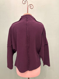 Back view of plum relaxed pullover showcasing center seam and dropped shoulders