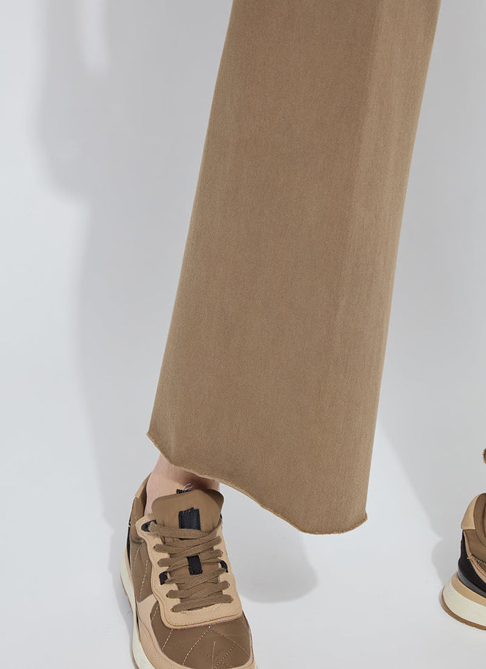 Close-up of raw-hem khaki wide-leg crop jeans paired with brown sneakers