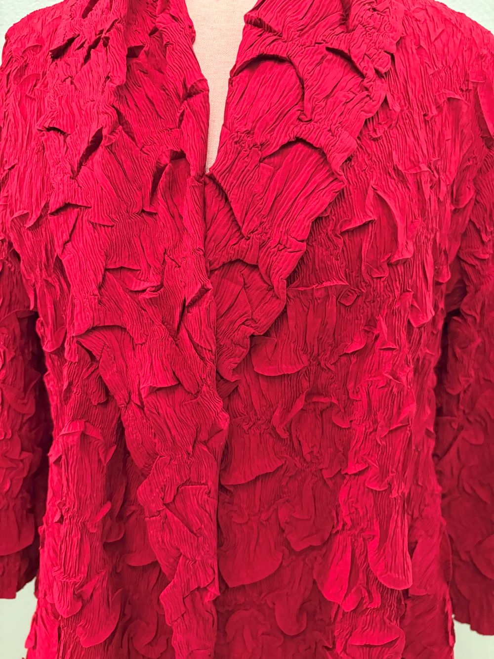 Close-up displaying rich red crinkle textured fabric and collar details