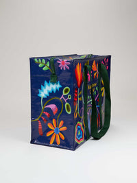 Side view of a large reusable tote bag with colorful floral designs on a navy background