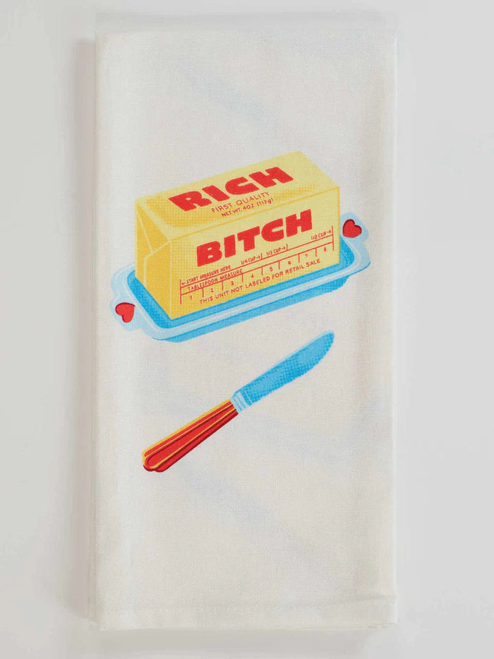 Kitchen towel featuring butter stick labeled 'Rich Bitch' with a colorful knife