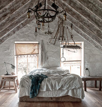 Back view of two women in lace, standing at a rustic wooden structure in sunlight